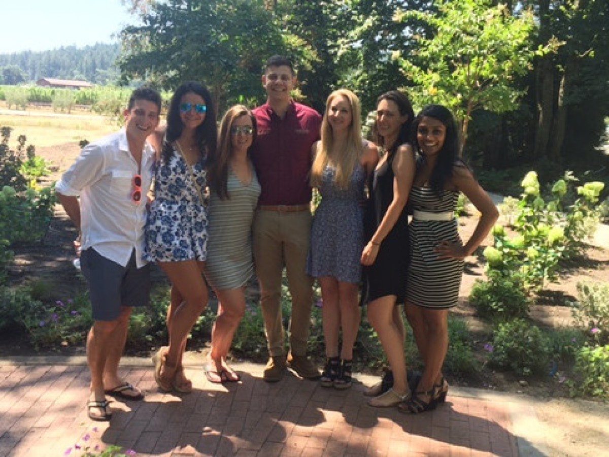 a group of people standing next to a tree