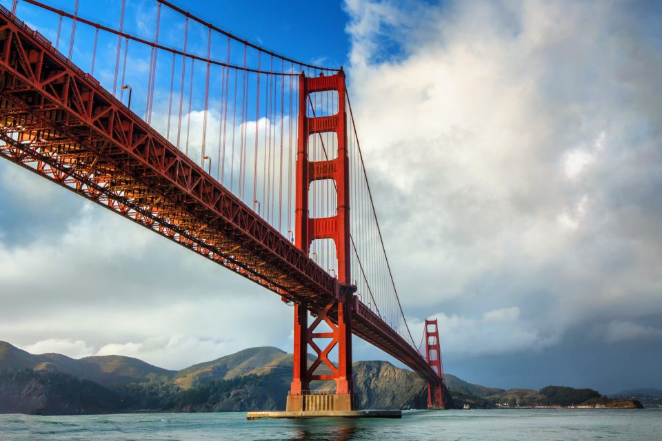 Golden Gate Bridge in San Francisco on a partly cloudy day a close up of a train crossing a bridge over a body of water